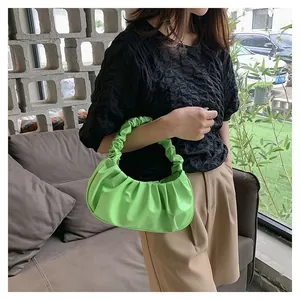 Close-up of bright green pleated cloud bag texture and vibrant ruched handle detail