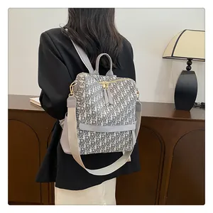 Détail d'un sac à dos vintage à monogramme avec grande capacité et sangles réglables