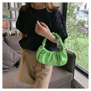 Detailed view of a bright green pleated cloud handbag with a gathered ruffle handle