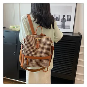Détail du sac à dos rétro en pied-de-poule avec poche latérale et texture en cuir