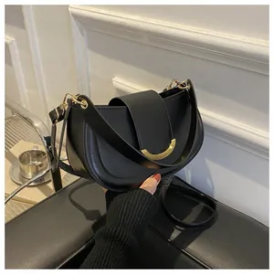 Detail view of a black saddle bag featuring a gold buckle and premium leather texture