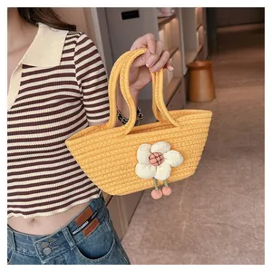 Detail der gelben Web-Handtasche mit 3D-Blumenapplikation und pinkfarbenen Kugelelementen