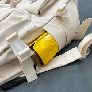 Dettaglio della tasca laterale di uno zaino in tela crema con un ombrello giallo