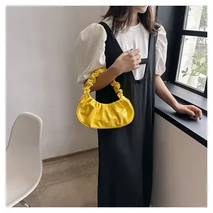 Detailed view of yellow ruched cloud bag with premium soft pleated leather texture