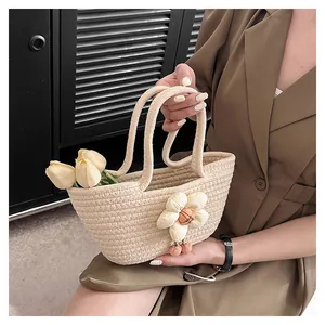 Detail der handgewebten beigen Tragetasche mit 3D-Blumenakzent und weichem Plüsch-Pompon