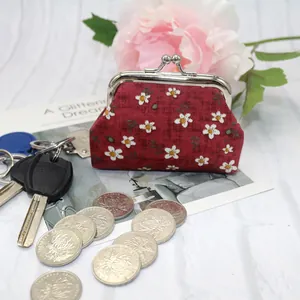 Detail of red floral coin purse with silver metal clasp and daisy pattern fabric
