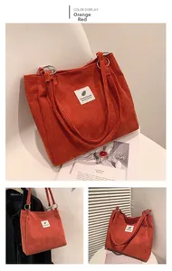 Macro view of orange red corduroy tote bag showing metal buckle and fabric patch detail