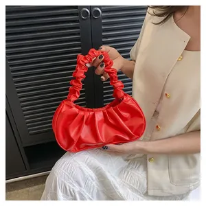 Detail of red pleated cloud bag with scrunchie handle and soft PU leather texture