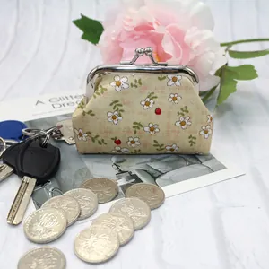 Detail of floral daisy print coin purse with vintage metal clasp on a textured background