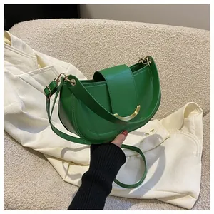 Close-up of bright green saddle bag with golden buckle on a white textured background