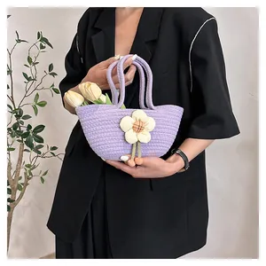 Detailaufnahme der lila Stricktasche mit weißen 3D-Blumen und rosa Anhänger