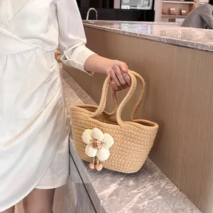 Handgewebte Strohtasche mit großer weißer Blume und rosa Kirschanhängern für Damen