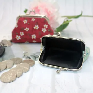 Close-up of floral fabric coin purses with silver metal clasps and interior lining detail
