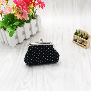 Black polka dot cotton coin purse with silver kiss-lock closure on wooden background