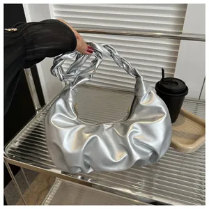 Detail of silver ruched cloud bag with woven handle and metallic finish for women