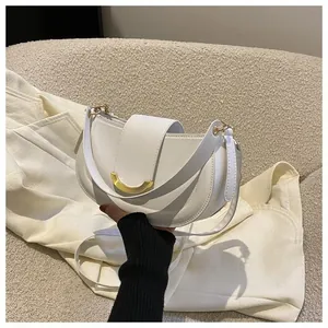 Detail of white saddle bag with golden crescent metal buckle and high-quality leather texture