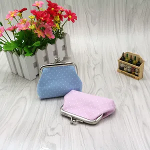 Detailed view of light blue and pink polka dot fabric coin purses with metal kiss locks