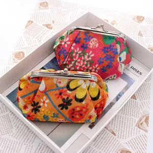 Close-up of vintage floral embroidery fabric coin purses with metal clasp in a gift box