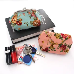 Detailed view of floral canvas coin purse with clasp and envelope wallet among daily items