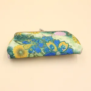 Gros plan de la broderie florale élégante sur un long portefeuille avec fermoir en métal doré