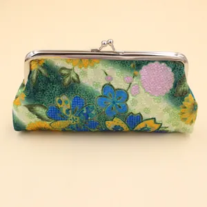 Gros plan d'un portefeuille brodé vintage avec motif floral et fermoir baiser argenté