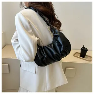 Detail of black pleated hobo bag with unique woven knot shoulder strap and matte finish