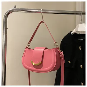 Pink saddle shoulder bag with golden crescent buckle and adjustable leather strap