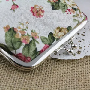 Close-up of vintage floral canvas coin purse with silver kiss-lock buckle and lace detail