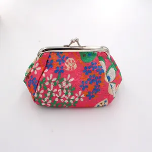 Detailed view of floral embroidered magenta coin purse with silver kiss-lock clasp