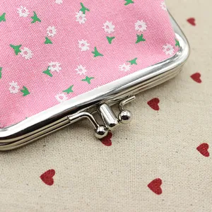 Detailopname van roze stoffen portemonnee met bloemenprint en zilveren kliksluiting