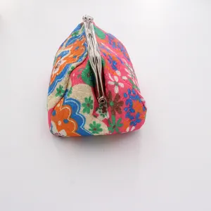 Detailed top view of a vintage floral embroidered coin purse with metal ball clasp closure