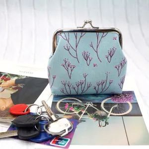 Détail d'un porte-monnaie vintage en toile bleue avec imprimé fleuri et fermoir en métal