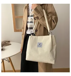 Cream corduroy tote bag with feather label and metal rings for school and commuting
