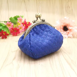 Vintage blue sequined quilted kiss-lock coin purse with bronze frame on wooden floor