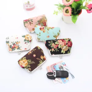 Five assorted floral canvas coin purses with vintage metal clasp on white background