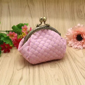 Macro detail of pink quilted coin purse with sequins and bronze kiss-lock frame