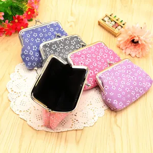 Floral fabric coin purses with metal clasps on a rustic wooden background