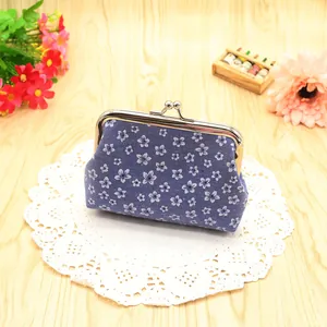 Detail view of a floral navy blue fabric coin purse with a vintage silver metal clasp
