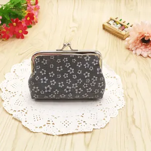 Close-up of floral canvas coin purse with silver metal kiss lock on lace coaster