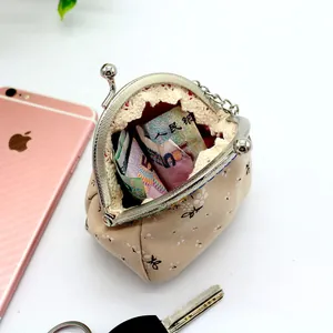 Vintage-Geldbörse mit Blumenmuster, Metallverschluss und Kette, gezeigt mit einem Handy