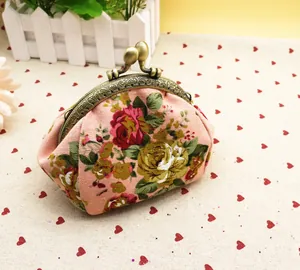 Détail du porte-monnaie floral en toile rose avec cadre en métal bronze et fermoir boule