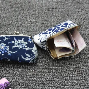 Detail van vintage canvas portemonnees met blauwe bloemmotieven en metalen sluiting