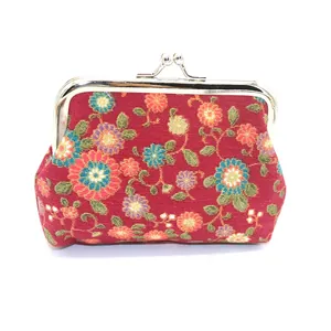 Detail van vintage stoffen portemonnee met kusssluiting en rood bloemenpatroon