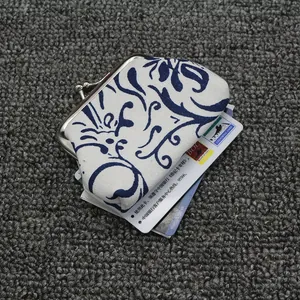 Detail van de vintage canvas portemonnee met blauwe bloemenprint en metalen kliksluiting