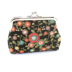Gedetailleerde close-up van een zwarte bloemenportemonnee met een vintage metalen kiss-lock