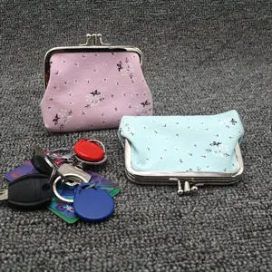 Close-up of small floral canvas coin purses with vintage metal clasp in pink and blue