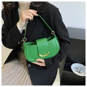 Detail of green leather saddle bag with gold metal buckle and thin shoulder strap