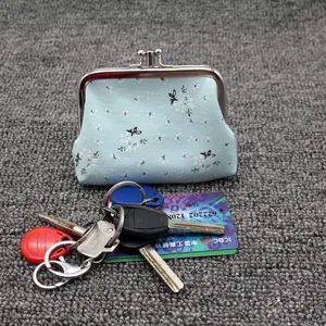 Detailed shot of a light blue floral canvas coin purse with silver metal kiss-lock clasp