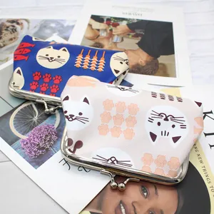 Detail of canvas cat coin purses with metal clasps on a stylish magazine background