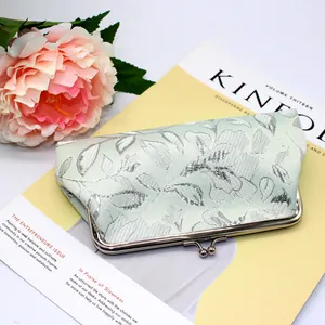 Detail of mint green floral jacquard long wallet with polished metal kiss-lock closure